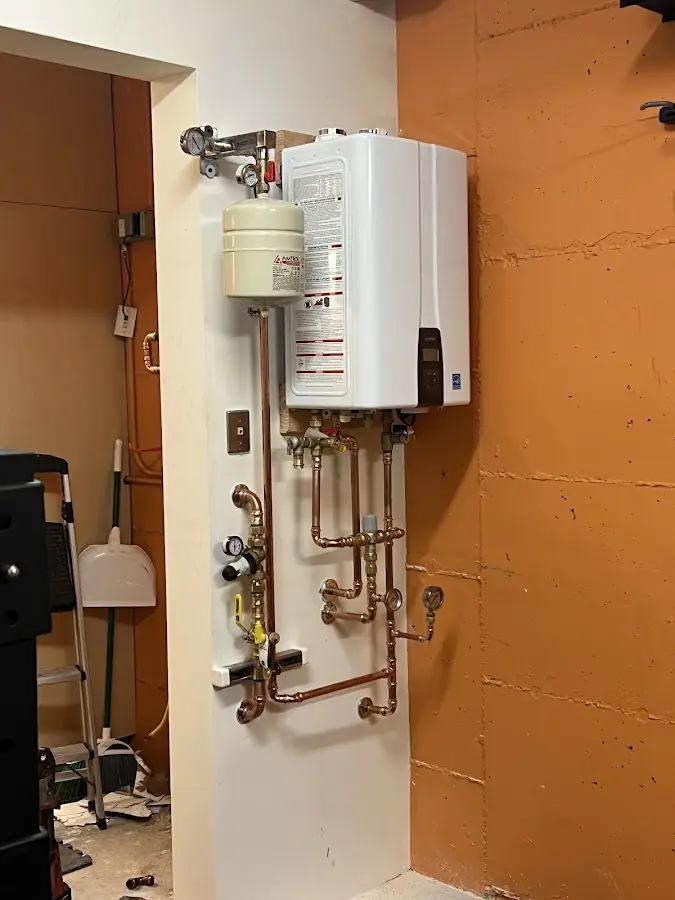 Plumbing technician inspecting water heater connections in Marlow